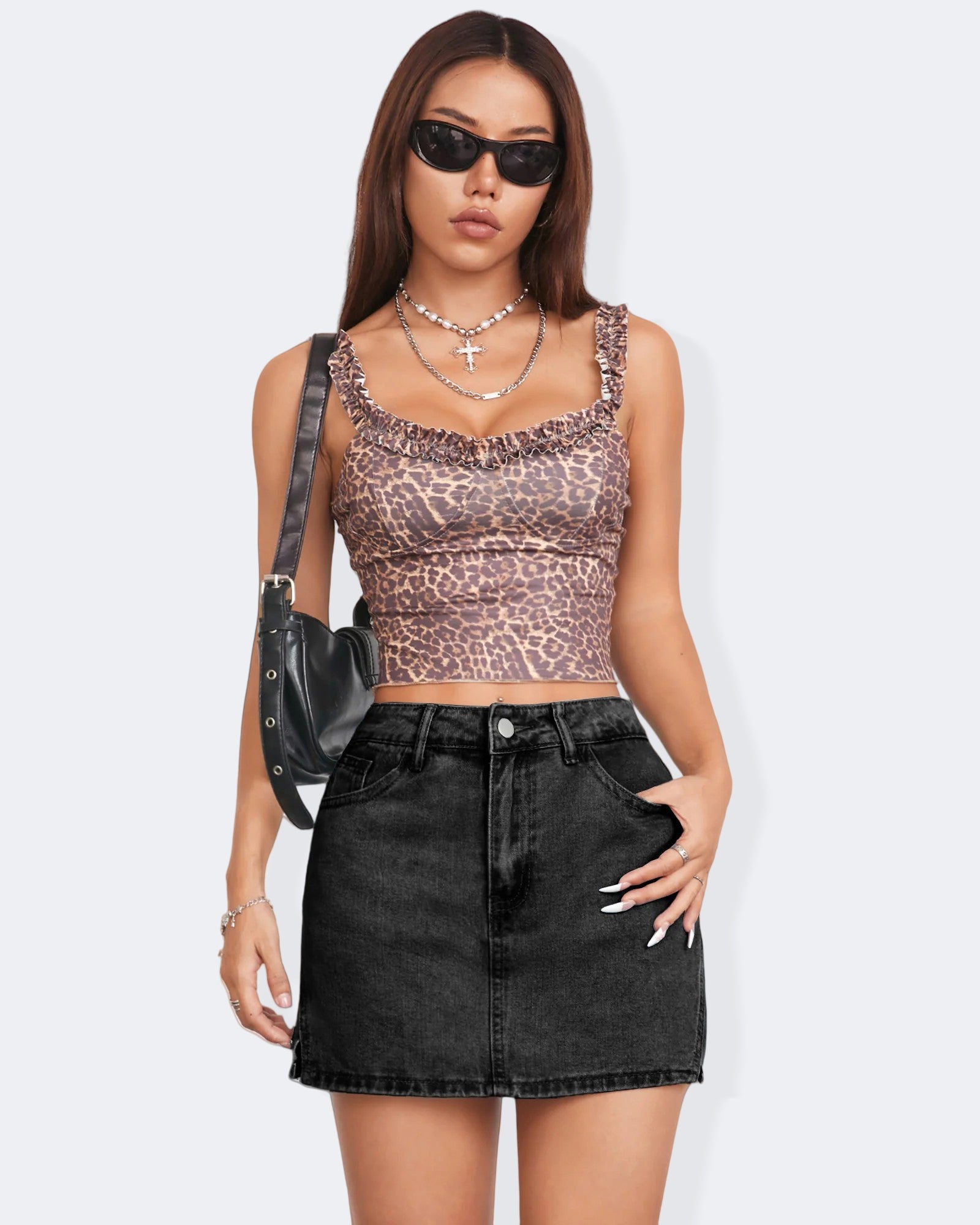 Model wearing a leopard print crop top and denim skort, showcasing trendy summer fashion with sunglasses and a black handbag.