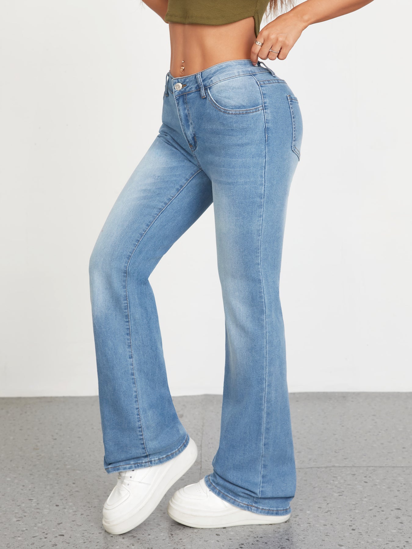 Low-rise flared bell bottom jeans in light wash, styled for women in casual wear, featuring stretchy denim for comfort.